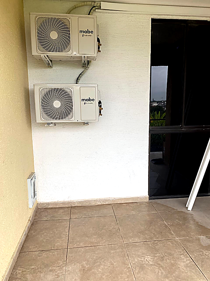 Técnico instalando unidad Mabe en habitación con vista al exterior